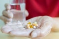 Selective focus of old man hands holding and taking pills with water glass Royalty Free Stock Photo