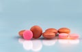 Selective focus on orange and pink round tablets with shadow on gradient background. Pharmaceutical industry. Pharmacy products. Royalty Free Stock Photo