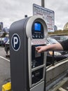 Selective focus on an outdoor public parking payment meter on Pike Street as a person begins the payment process Royalty Free Stock Photo