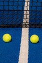 Selective focus, paddle tennis balls on a blue paddle tennis court close to the net Royalty Free Stock Photo