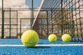 Selective focus, paddle tennis balls on a blue paddle tennis court close to the net, racket sports concept Royalty Free Stock Photo