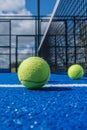 Selective focus, paddle tennis balls on a blue paddle tennis court close to the net Royalty Free Stock Photo