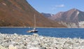 Selective focus. Pebble beach in the Northern Bay of the Pacific ocean with one boat at anchor Royalty Free Stock Photo