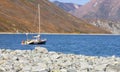 Selective focus. Pebble beach in the Northern Bay of the Pacific ocean with one boat at anchor Royalty Free Stock Photo
