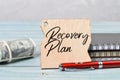 Selective focus of pen, notebooks, pen and label tag written with RECOVERY PLAN Royalty Free Stock Photo