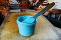 Selective focus photo of can of blue paint on wooden shelve on the print screening apparatus. serigraphy production