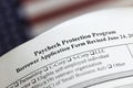 selective focus photo of paycheck protection program borrower application form revised  on a background of United States flag. Royalty Free Stock Photo