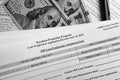 Selective focus photo of paycheck protection program loan forgiveness application form revised, on a background of dollar bills Royalty Free Stock Photo