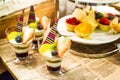 Selective focus photo of Seasonal Tropical Fruit creamy trifle in beautiful glasses with fresh ripe fruit slice, table background Royalty Free Stock Photo