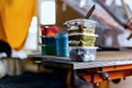 Selective focus photo of various paints on wooden shelve on the print screening apparatus. serigraphy production. printing images