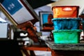 Selective focus photo of various paints on wooden shelve on the print screening apparatus. serigraphy production. printing images