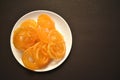 Selective focus picture of Indian Traditional Sweet called Jelebi kept in white plate in flat lay