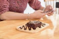 Selective focus on piece of brownie cake with blured two hands u