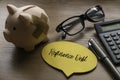 Selective focus of piggy bank, glasses. calculator, pen and yellow speech bubble written with Refinance Debt on wooden background