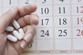 Selective focus at pills and calendar with blurry hand Royalty Free Stock Photo