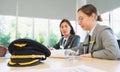 Selective focus at pilot hat on table and working women of airline at background in meeting room. Business group meeting or job Royalty Free Stock Photo