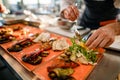 selective focus on plate with dish which man cook decorates with sauce