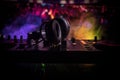 In selective focus of Pro dj controller.The DJ console deejay mixing desk at music party in nightclub with colored disco lights.