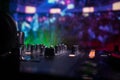 In selective focus of Pro dj controller.The DJ console deejay mixing desk at music party in nightclub with colored disco lights.