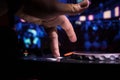 In selective focus of Pro dj controller.The DJ console deejay mixing desk at music party in nightclub with colored disco lights.