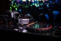 In selective focus of Pro dj controller.The DJ console deejay mixing desk at music party in nightclub with colored disco lights. Royalty Free Stock Photo