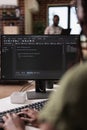 Selective focus on programmer typing code on computer keyboard while roommate is relaxing Royalty Free Stock Photo