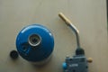Selective focus on propane gas canister with blurred nozzle and head of blowtorch in the background