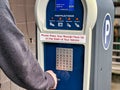 Selective focus on a public parking payment meter as a person makes a payment Royalty Free Stock Photo