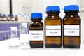 Selective focus of pure dichloromethane, chloroform and tetrachloromethane liquid chemical compound set in dark glass bottles.