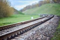 Selective focus railway track turns and twists between hills. Empty rounding and turning single track of railways