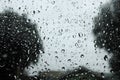 Selective focus of rain water droplets on house glass window. Rainy season background. Royalty Free Stock Photo