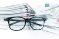 Selective focus on reading eyeglasses with stacking of newspaper Royalty Free Stock Photo