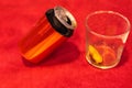 selective focus of a red and black soda can tilted together with a crystal glass with ice and lemon Royalty Free Stock Photo