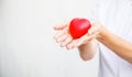 Selective focus of red heart held by female nurse`s both hand, representing giving all effort to deliver high quality service mind