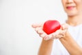 Selective focus of red heart held by smiling female nurse`s both hand, representing giving all effort to deliver high quality Royalty Free Stock Photo
