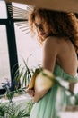 Focus of redhead woman with accessory on head posing with bananas