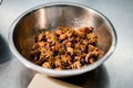 Selective focus on roasted small octopuses in metal bowl.