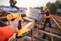 Selective focus Roofing tools, Roofer worker holding electric drill used on new roofs with Metal Sheet at construction site