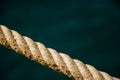 Selective focus on rope texture on blurred sea surface background. Stretched sea cable. Old nautical cord. Sea background with Royalty Free Stock Photo