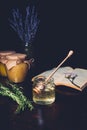 selective focus of rosemary and honey stick in jar with honey on black