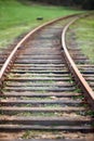 Selective focus rounding of railway abandoned rusty, overgrown with grass and moss. Empty turning single track of Royalty Free Stock Photo