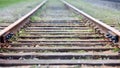 Selective focus rounding of railway abandoned rusty, overgrown with grass and moss. Empty turning single track of