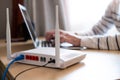 Selective focus at router. Internet router on working table with blurred man connect the cable at the background. Fast and high Royalty Free Stock Photo