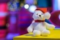 Santa claus teddy bear eyes who wearing hat sitting in front of colorful blurred background Royalty Free Stock Photo