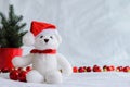 anta claus teddy bear eyes who wearing hat sitting with red baubles and Christmas tree Royalty Free Stock Photo