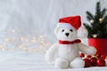 Santa claus teddy bear eyes who wearing hat sitting with red baubles and Christmas tree Royalty Free Stock Photo