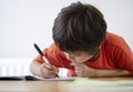 Selective focus of school kid boy siting on table doing homework with white background, Happy Child holding black pen,Little boy i Royalty Free Stock Photo