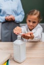 Selective focus of schoolgirl applying antiseptic Royalty Free Stock Photo