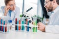 selective focus of scientists in eyeglasses at workplace with flasks and microscope Royalty Free Stock Photo