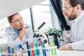 selective focus of scientists in eyeglasses at workplace with flasks and microscope Royalty Free Stock Photo
